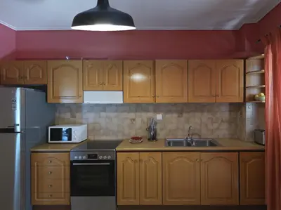 a kitchen with wooden cabinets and a sink at 2 bedroom apartment close to children's hospital in Athens