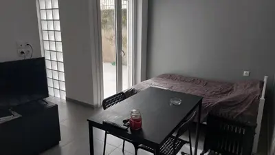 a room with a table and a bed with a drink on it at Cozy Nest in Athens