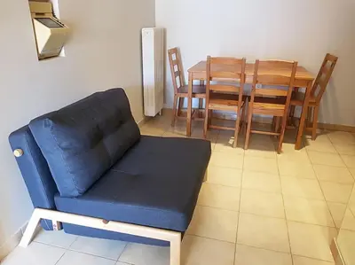 a living room with a blue couch and a table at Athens Campus Renovated Studio Apartment @ Ilisia in Athens