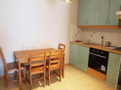 a kitchen with a wooden table and chairs and a sink at Athens Campus Renovated Studio Apartment @ Ilisia in Athens
