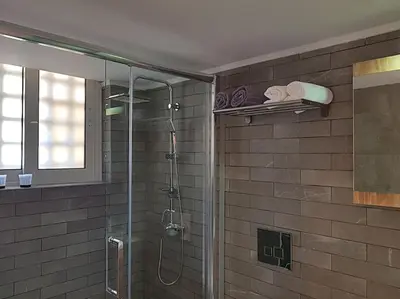 a bathroom with a shower with a glass door at Athens Campus Renovated Studio Apartment @ Ilisia in Athens