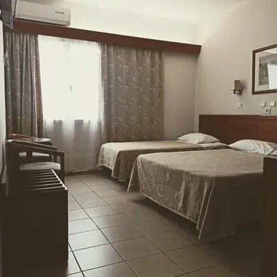 a hotel room with two beds and a window at Hotel Solomou Athens in Athens