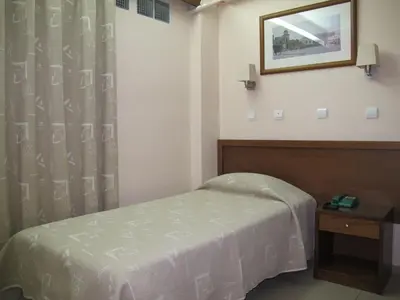 a room with a bed and a table and a mirror at Hotel Solomou Athens in Athens
