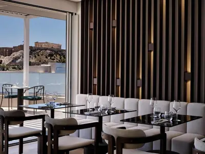 a dining room with tables and chairs and a window at Electra Rhythm Athens in Athens