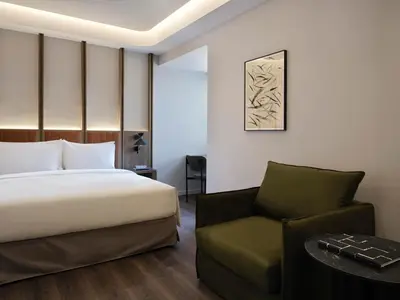 a hotel room with a bed and a chair at Electra Rhythm Athens in Athens