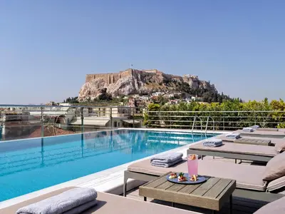 a resort with a pool with a mountain in the background at Electra Palace Athens in Athens