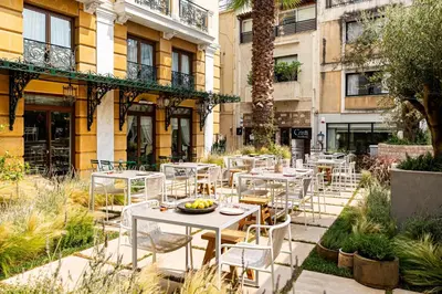 a group of tables and chairs in front of a building at Electra Palace Athens in Athens