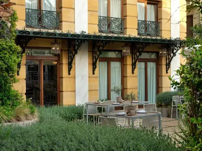 a table and chairs in front of a building at Electra Palace Athens in Athens