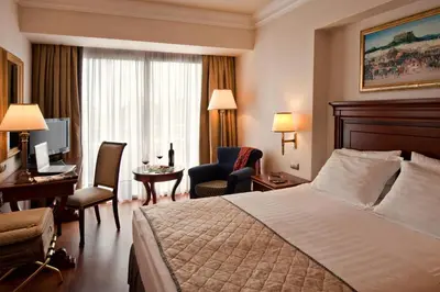a hotel room with a bed and a desk and a computer at Electra Palace Athens in Athens