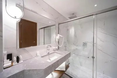 a bathroom with a sink and a glass shower at Electra Palace Athens in Athens