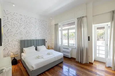 a bedroom with a large white bed and a window at An Outstanding 3 bdrm Apartment in the Heart of Athens in Athens
