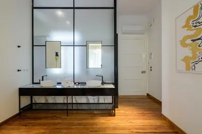 a bathroom with two sinks and a mirror at An Outstanding 3 bdrm Apartment in the Heart of Athens in Athens