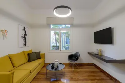 a living room with a yellow couch and a table at An Outstanding 3 bdrm Apartment in the Heart of Athens in Athens