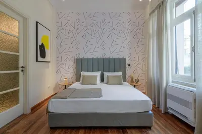 a bedroom with a large bed and a wall at An Outstanding 3 bdrm Apartment in the Heart of Athens in Athens