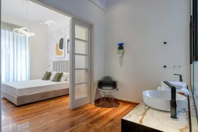 a bathroom with a sink and a bed and a mirror at An Outstanding 3 bdrm Apartment in the Heart of Athens in Athens