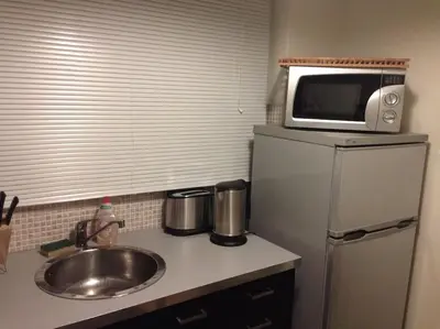 a kitchen with a sink and a microwave on top of a refrigerator at Acropolis Steps, City Apartment in Athens