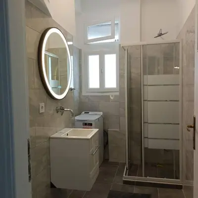 a bathroom with a sink and a mirror and a shower at GAYA apartments in Athens