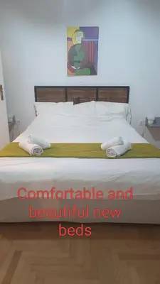 a bed with two towels on it with the words comfortable and beautiful new beds at GAYA apartments in Athens