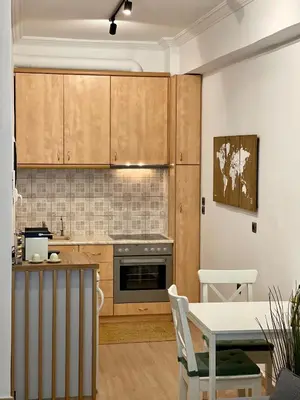 a kitchen with wooden cabinets and a table and a dining room at Stay Calm in Athens