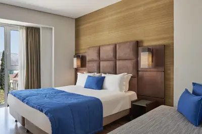a hotel room with a large bed and a window at Arion Athens Hotel in Athens