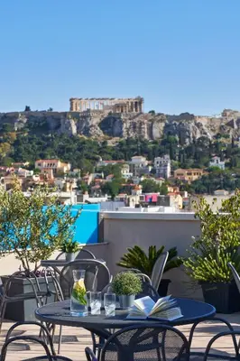 a table and chairs with a view of a city at Arion Athens Hotel in Athens