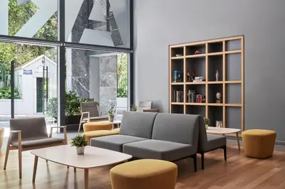 a living room with a couch and chairs and tables at Arion Athens Hotel in Athens