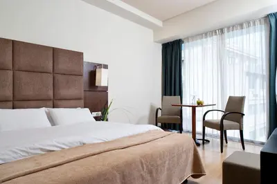 a bedroom with a bed and a table and chairs at Arion Athens Hotel in Athens