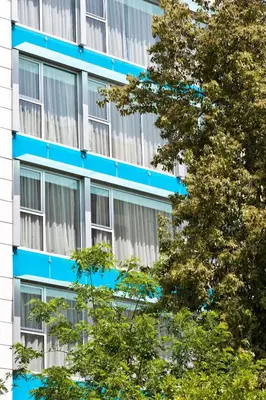 a blue building with trees in front of it at Arion Athens Hotel in Athens