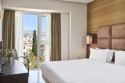 a hotel room with a large bed and a window at Arion Athens Hotel in Athens