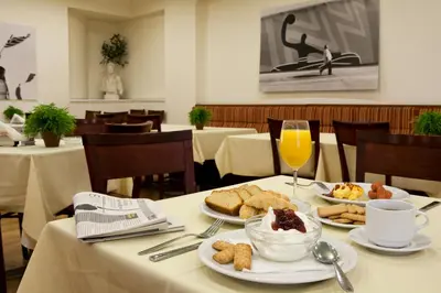 a table with plates of food and a glass of orange juice at Hermes Hotel in Athens