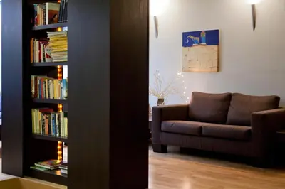 a living room with a couch and a book shelf with books at Hermes Hotel in Athens