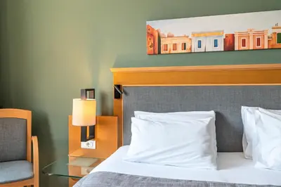 a hotel room with a bed and a chair and a table at Plaka Hotel in Athens