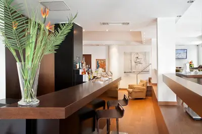 a dining room with a long table with a vase at Plaka Hotel in Athens