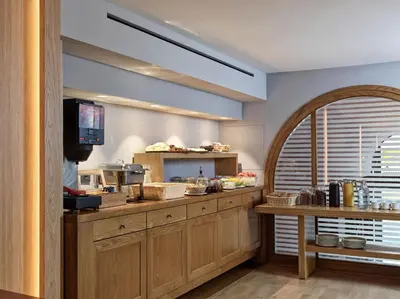 a kitchen with wooden cabinets and a counter with a tv at Hotel Achilleas in Athens