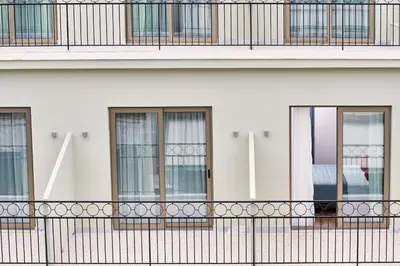 a white building with windows and a black fence at Hotel Achilleas in Athens