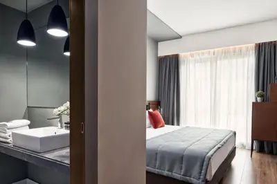 a bedroom with a bed and a bathroom with a sink at Hotel Achilleas in Athens