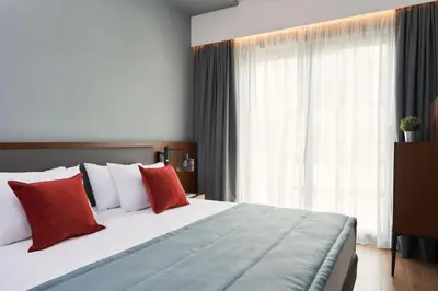 a bedroom with a large bed with red pillows at Hotel Achilleas in Athens