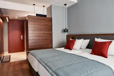 a hotel room with a bed with red pillows at Hotel Achilleas in Athens