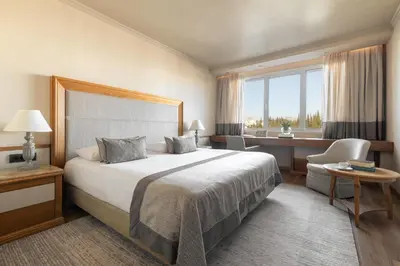 a hotel room with a large bed and a desk at Divani Caravel in Athens