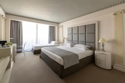 a hotel room with two beds and a large window at NJV Athens Plaza in Athens