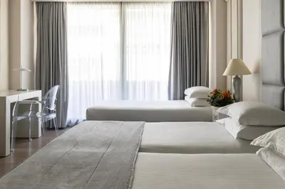 a hotel room with two beds and a window at NJV Athens Plaza in Athens