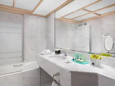 a bathroom with a sink and a tub and a mirror at NJV Athens Plaza in Athens