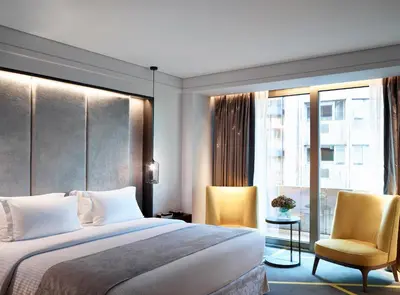 a hotel room with a bed and two chairs at NJV Athens Plaza in Athens