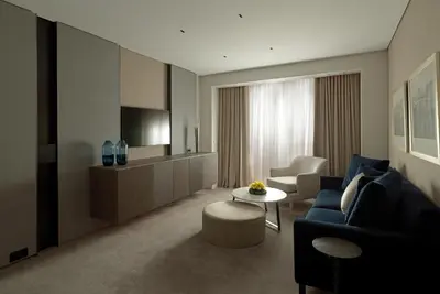 a living room with a blue couch and a tv at NJV Athens Plaza in Athens