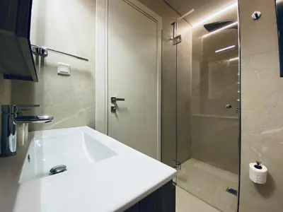 a bathroom with a white sink and a shower at Athens Riviera 2-Bed Apt & Pool Access #Unoblu® in Athens