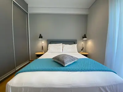 a bedroom with a large bed with a blue blanket at Athens Riviera 2-Bed Apt & Pool Access #Unoblu® in Athens