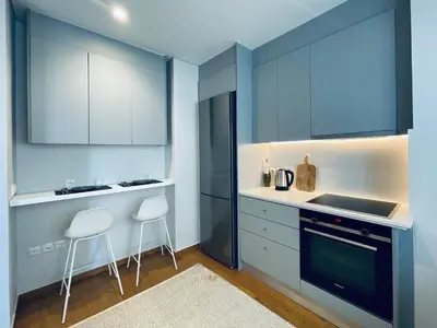 a kitchen with blue cabinets and white counters at Athens Riviera 2-Bed Apt & Pool Access #Unoblu® in Athens