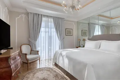 a bedroom with a large bed and a mirror at King George, a Luxury Collection Hotel, Athens in Athens