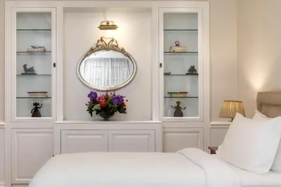 a white bedroom with a bed and a mirror at King George, a Luxury Collection Hotel, Athens in Athens