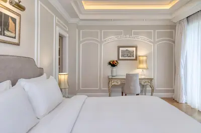a bedroom with a white bed and a desk at King George, a Luxury Collection Hotel, Athens in Athens